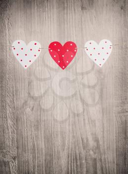 Three Valentines Day hearts on vintage wooden background as Valentines Day  symbol