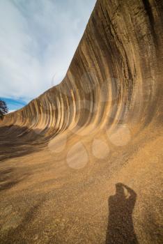 Fantastic Wave Rock in the Wave Rock Wildlife Park near Hyden in Western Australia.Wide angle shot with man's shadow.
