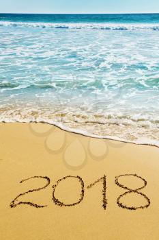 digits  2018 on the sand seashore - concept of New Year and  Xmas