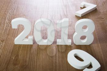 White digits 2018 and digit 7 and 9 on rustic  wooden background as concept of New Year and Christmas.