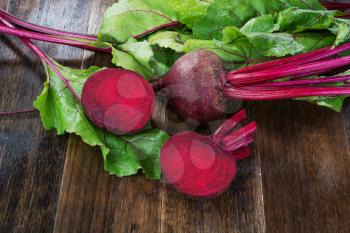  Fresh beetroots with leaves on wooden rustic table.Whole and cut  beetroots 
