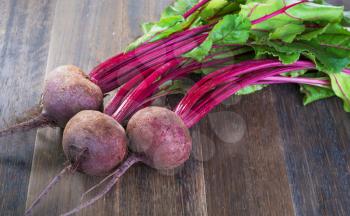  Fresh whole beetroots with leaves on wooden rustic table.Whole  beetroots 