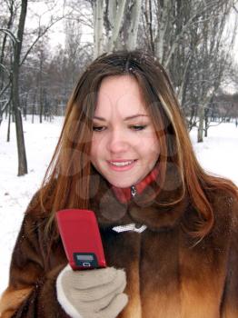 Royalty Free Photo of a Girl With a Cellphone in a Park in Winter