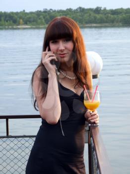Royalty Free Photo of a Woman Talking on the Phone and Holding a Drink