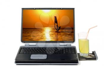 Royalty Free Photo of a Laptop With a Sunset Scene Beside a Drink