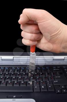 Royalty Free Photo of a Hand Putting a Knife in a Keyboard