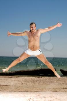 Royalty Free Photo of a Man Jumping on the Beach