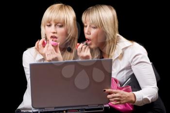 Royalty Free Photo of Girls Putting on Makeup in Front of a Laptop