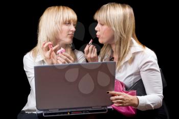 Royalty Free Photo of Two Women Putting on Makeup in Front of a Laptop