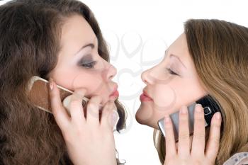 Royalty Free Photo of Two Girls on Cellphones Appearing Ready to Kiss