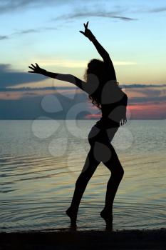 Royalty Free Photo of a Woman on the Beach at Sunset