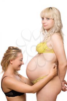 Royalty Free Photo of a Pregnant Woman With Another Women Looking at Her Belly