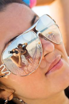 Royalty Free Photo of a Photographer and Woman Reflected in a Woman's Sunglasses