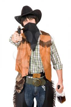 Royalty Free Photo of a Cowboy Holding a Bottle and Pointing a Gun