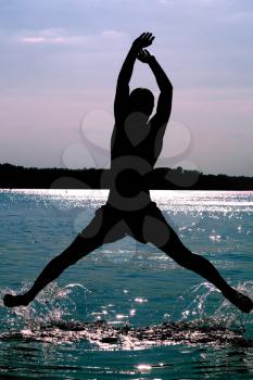 Royalty Free Photo of a Man Jumping in Front of the Water