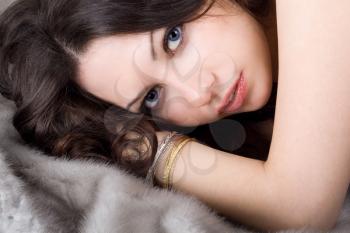 Royalty Free Photo of a Woman Lying on Grey Fur