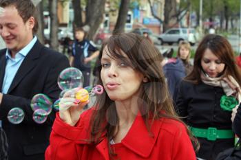 Royalty Free Photo of a Woman Blowing Bubbles in the City