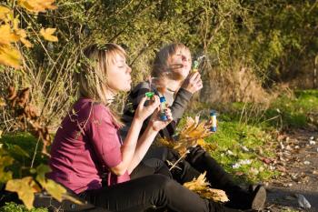 Royalty Free Photo of Two Women Blowing Soap Bubbles in the Park