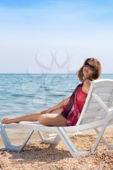 Royalty Free Photo of a Woman on a Chair at the Beach
