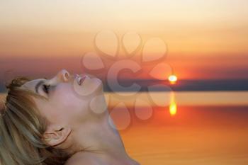 Royalty Free Photo of a Woman Leaning Back With a Sunset Behind