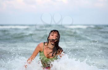 Cheerful wet young woman in the sea