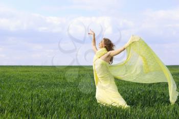 Charming young woman in a green field