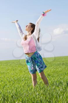 Happy nice young woman in a green field