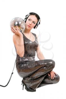 Nice young brunette in headphones with a mirror ball. Isolated on white