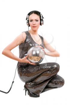 Young brunette in headphones with a mirror ball. Isolated on white