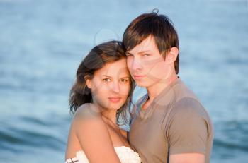 Closeup portrait of a beautiful young couple on the beach