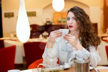 Beautiful young woman drinking tea in a cafe