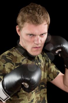 Portrait of angry young man in boxing gloves. Isolated