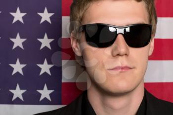 Man in sunglasses on a background of the American flag. Closeup