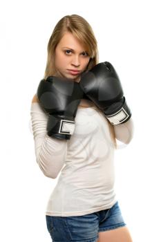 Young serious woman in white blouse posing with boxing gloves. Isolated 
