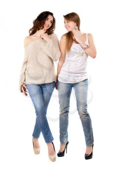 Two joyful women posing in blue jeans and high heels. Isolated on white