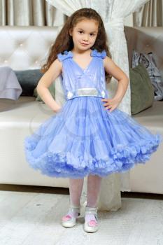 Pretty little girl wearing lace blue dress posing indoors