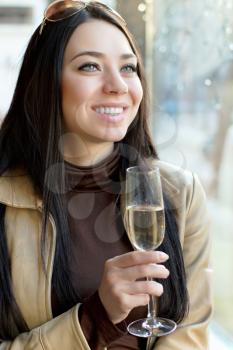 Portrait of beautiful cheerful woman with a glass of champagne. Isolated on white