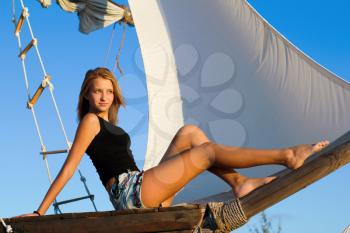 Attractive teen girl sitting at stern of the ship