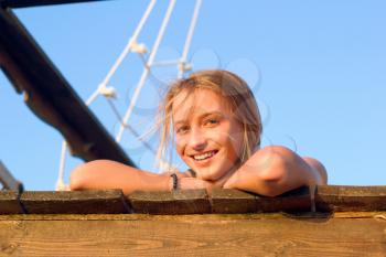 Smiling girl lying on the deck of an old wooden ship