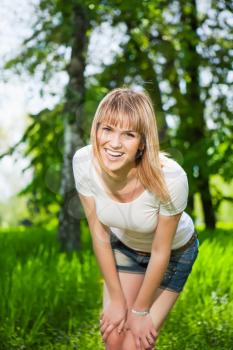 Portrait of young joyful woman posing in the park
