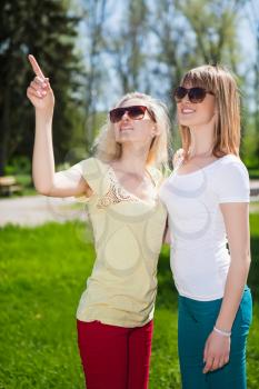 Portrait of two beautiful women posing in the park