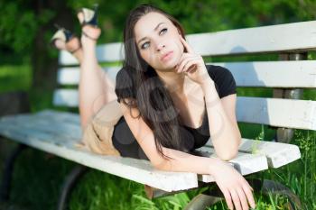 Pretty thoughtful brunette posing on the bench