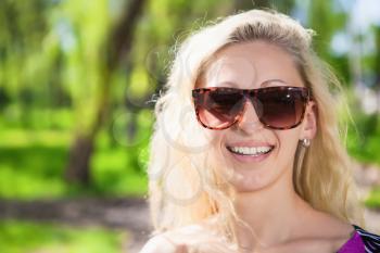 Portrait of smiling blonde posing in the park