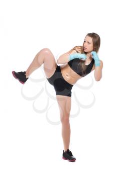 Young woman posing and kicking. Isolated on white