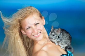 Smiling young blond woman posing with chinchilla