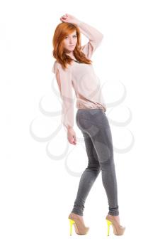 Pretty young woman posing in beige blouse and tight leggings. Isolated on white