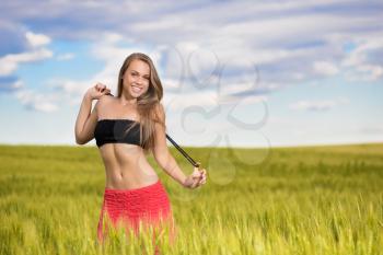 Cheerful young woman in black bra posing on the field