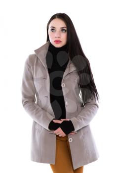Attractive young brunette in beige coat and black jersey. Isolated on white