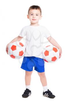 Smiling little boy posing with a two soccer balls. Isolated on white