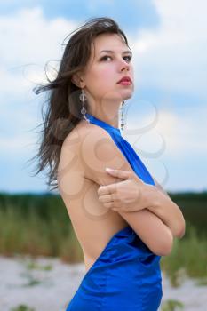 Alluring sexy brunette posing in blue fashionable dress
